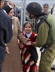 فتاة فلسطينية تبكي فيما والدتها تساجل إحدى جنديات الاحتلال على حاجز الحوارة قرب نابلس شمالي الضفة الغربية أمس